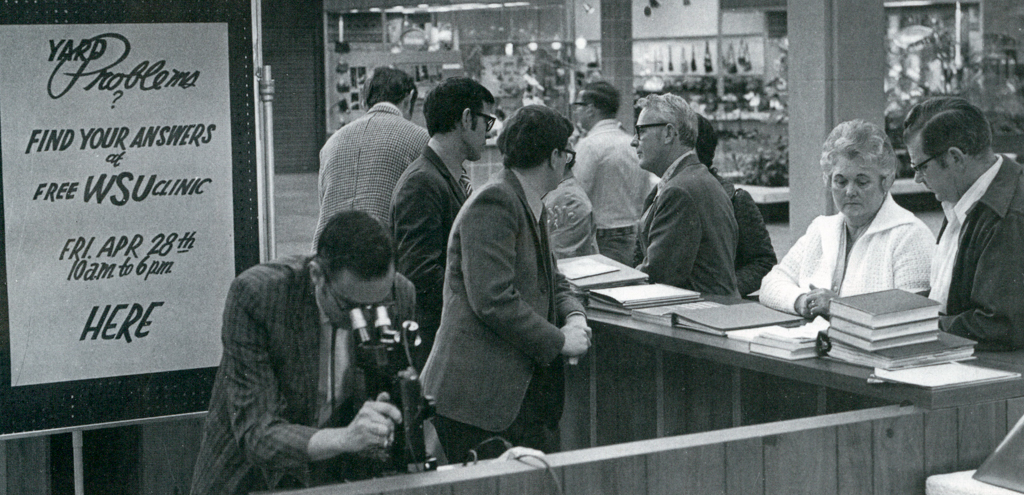 Original Master Gardener Plant Clinic in 1973; several Master Gardeners helping several members of the public.